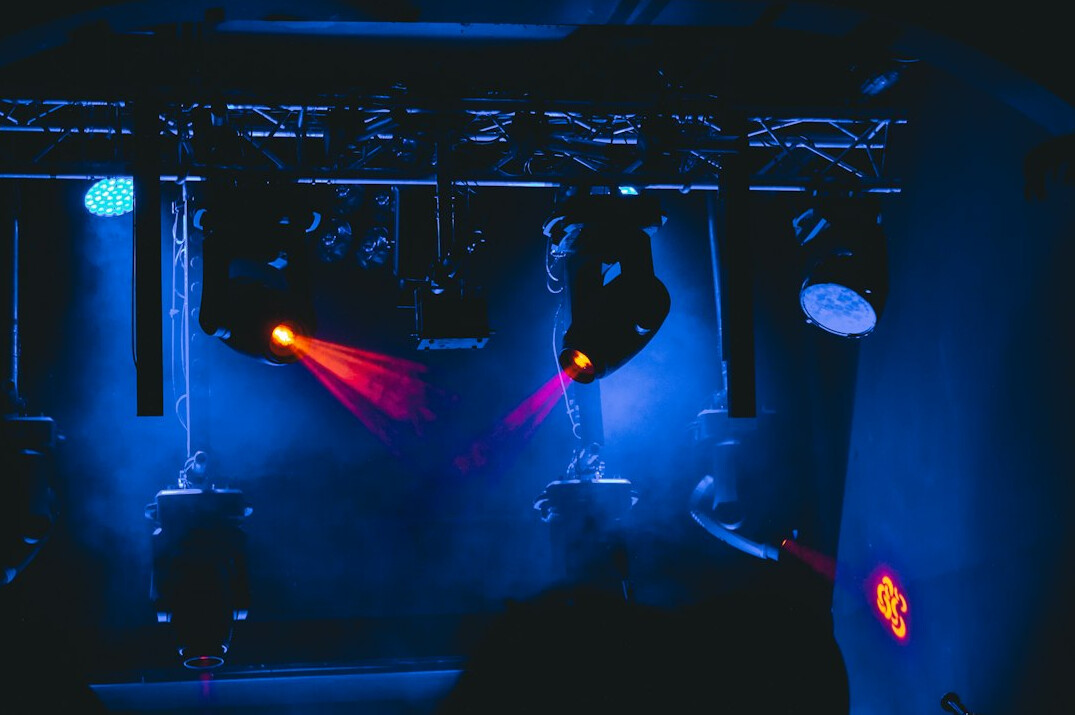 Studio lighting rig with warm spotlights above a stage